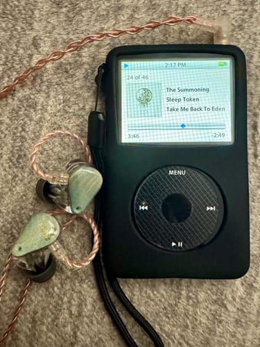 Reviewer's Moondrop Blessing 2 headphones with a braided copper cable, paired with an iPod playing music.