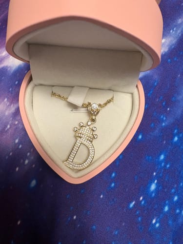 Reviewer's 14K Hollow Rope Chain with a sparkly initial pendant, displayed in a pink heart-shaped box.