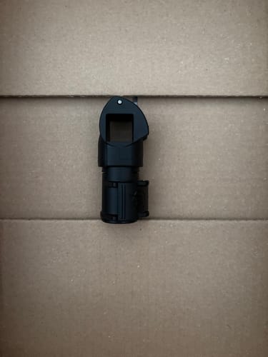 Recensent toont de zwarte SNAP LOK ACCESSORY BLOCK tegen een neutrale achtergrond.