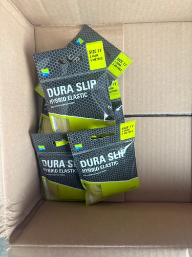 Klant toont een voorraad DURA SLIP HYBRID ELASTIC verpakkingen in een kartonnen doos.