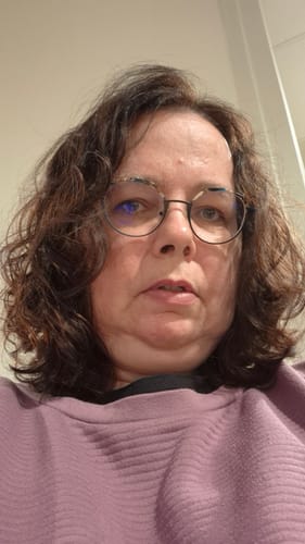 Recensent met krullend, bruin haar na gebruik van de Ted Hilley Ionische Fohn.