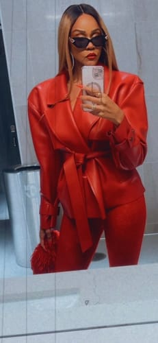 Customer takes a mirror selfie in a red Vegan Leather Cropped Trench Jacket, belted over matching pants.