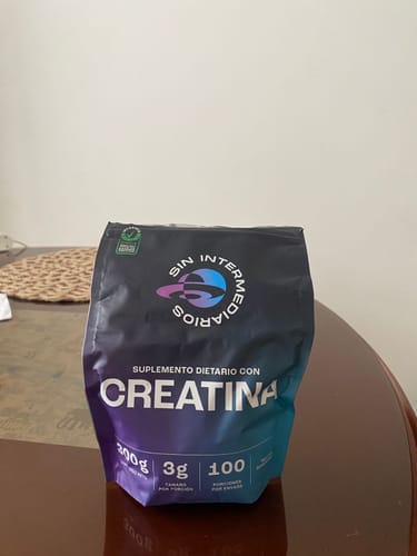 Reseñador muestra la bolsa de Creatina Monohidrato de 300g sobre una mesa.