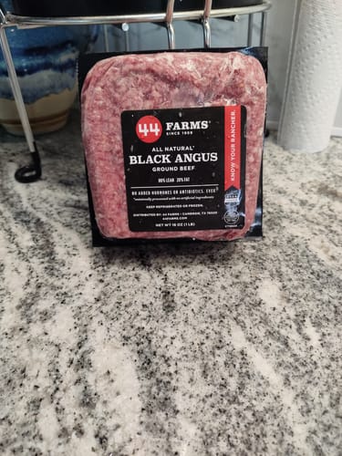 Customer's package of 44 Farms Black Angus ground beef in its vacuum-sealed packaging on a kitchen countertop.