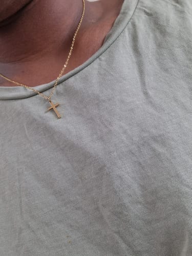 Customer's close-up view of the simple, gold Cross Necklace being worn.