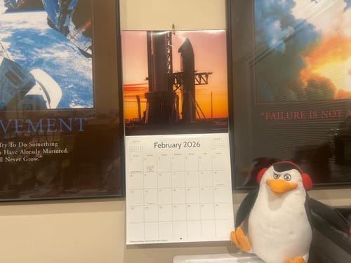 Reviewer's 2026 Starbase Calendar hanging on a wall in a home office, open to the February page.