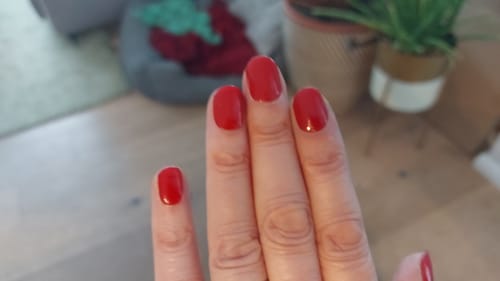 Hand einer Kundin, die die aufgetragenen 'Burning Lava' UV-Gelfolien in einem satten Rotton zeigt.