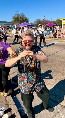 Customer wearing the Universal Monsters "Street Art Scare-athon" shirt and beads at a sunny parade.
