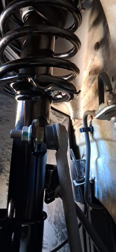 Reviewer's close-up photo of the black shock absorber installed in the wheel well of their car.