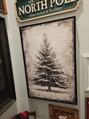 Customer's Vintage Pine Tree Christmas Wall Art with a black frame hanging in a decorated hallway.