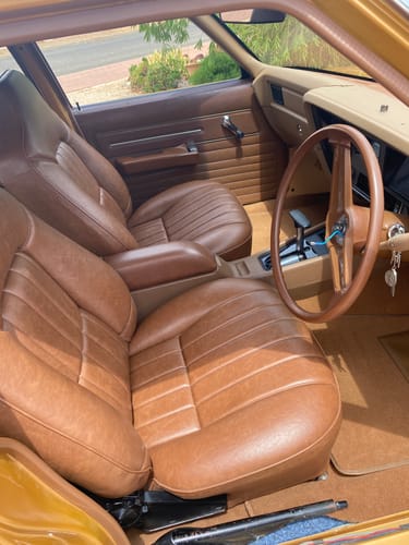 Reviewer's classic car interior with brown leather seats before applying the seat covers.