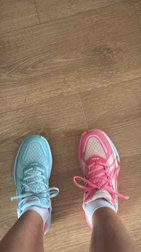 Reviewer wearing a mismatched pair of BIG3 4.0 Quick 'Reverse' shoes, with one light blue shoe and one pink shoe.