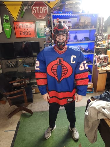 Reviewer standing front-on wearing the Cobra GI Joe Hockey Jersey and a red goalie helmet.
