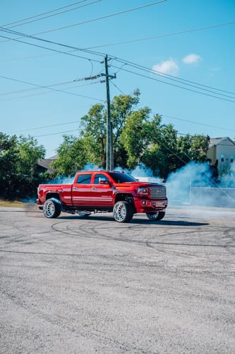 Customer's digital wallpaper from a QUICK ENTRY purchase, showing a red truck surrounded by smoke in a lot.