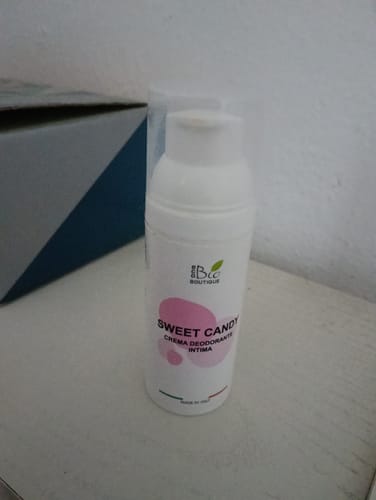 Recensione cliente: il flacone bianco della crema intima Sweet Candy appoggiato su una superficie chiara.