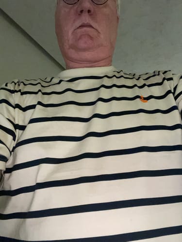 Kunde, der die Passform des gestreiften Mooinzen Bio T-Shirts zeigt.