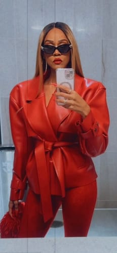 Close-up of the reviewer in the red Vegan Leather Cropped Trench Jacket, showing the lapels and belted tie.