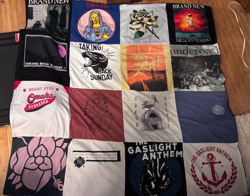 Customer's Premium T-Shirt Quilt made from various band t-shirts, including Brand New and Taking Back Sunday, on a floor.