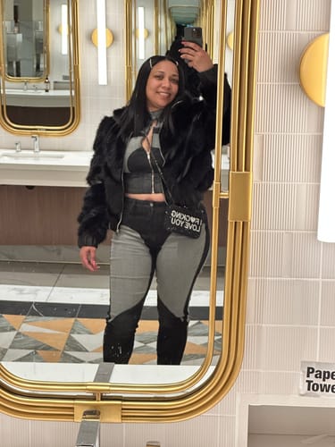 Reviewer taking a mirror selfie, showing the black IFLY Rhinestone Clutch worn crossbody with a fur jacket.