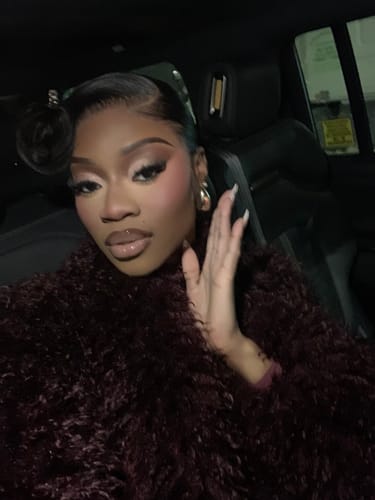 Reviewer in a car wearing the plush, dark burgundy Faux Fur Plush Long Coat.
