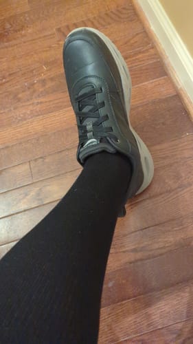 Reviewer's leg wearing black Performance Eucalyptus Compression Socks with a black sneaker.