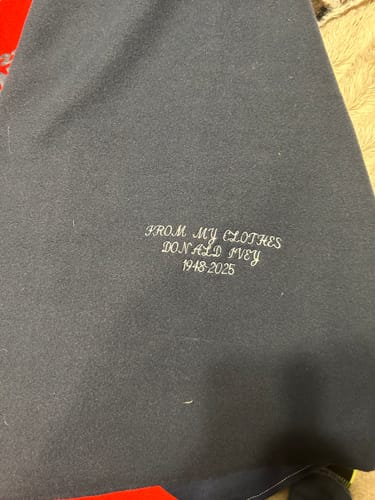 Close-up: A personalized memorial message embroidered on the navy fleece of a customer's Premium T Shirt Quilt.