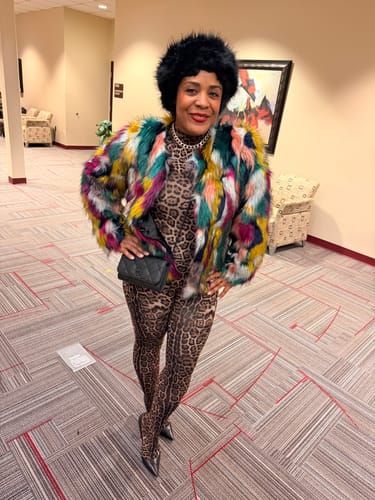 Reviewer styling the Naked Print Closed Toe Jumpsuit with a colorful faux fur coat.