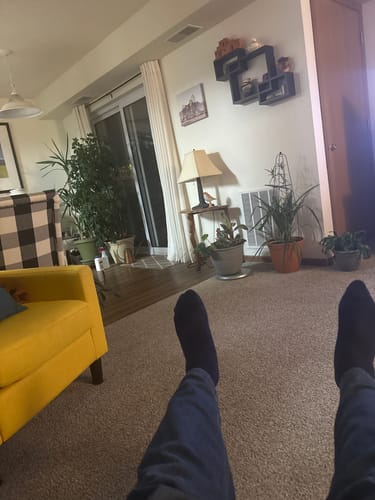 Reviewer wearing dark Performance Eucalyptus Compression Socks while relaxing in their living room.