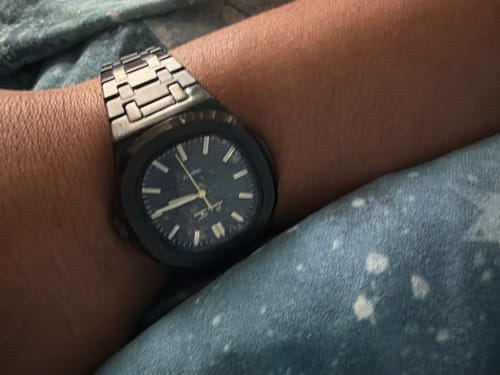 Close-up of a customer wearing the Lucky Fours® Brone watch, showing its dark face and linked metal band.