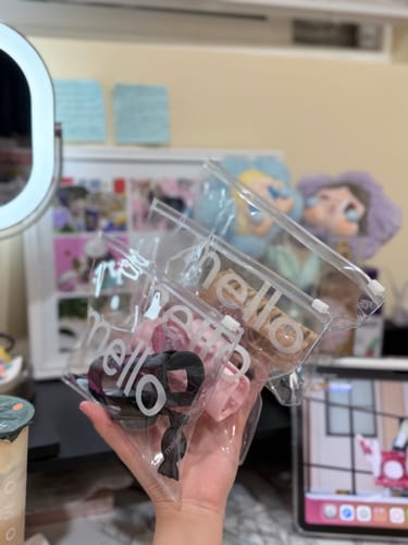 Customer holding several cloud clips in black, pink, and brown, each in a clear branded pouch.