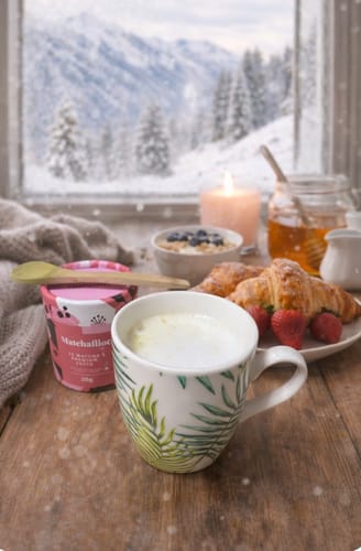 Foto de cliente del Té Matcha Premium 100% preparado en una taza para un desayuno acogedor con vistas a la nieve.