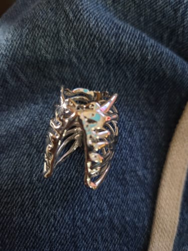 Close-up of a customer's silver RIBCAGE RING resting on a denim surface.