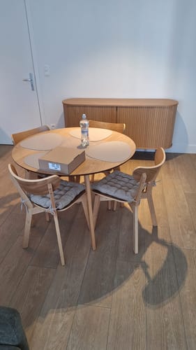 Klant toont de eikenhouten by fonQ Crow eetkamerstoelen rond een bijpassende tafel in een eetkamer.