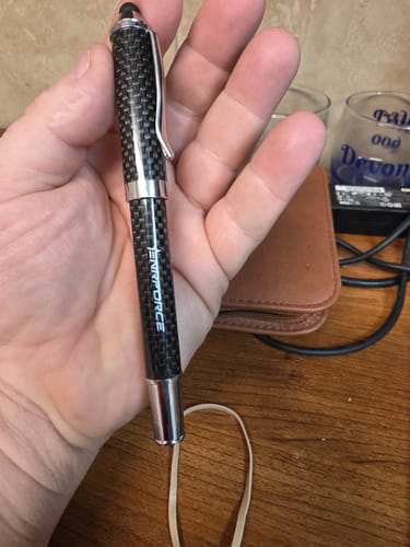 Customer holding the sleek Carbonstrike Pen, showing its black carbon-fiber pattern and stylus tip.