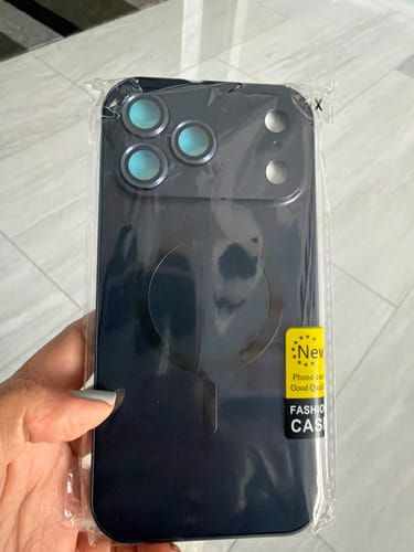 Reviewer holding the new MagCase Metal phone case in its clear packaging, showing the MagSafe ring.