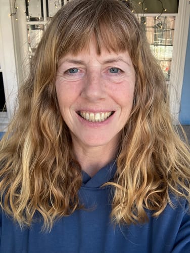 Reviewer smiling, showing her blended strawberry blonde hair after using the Instant Dye Shampoo.