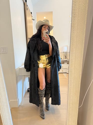 Reviewer in a mirror selfie showing the long, oversized fit of the black Faux Mink Long Coat.