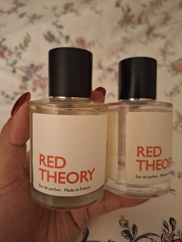 Reviewer holding their new bottle of Red Theory perfume next to their finished one.