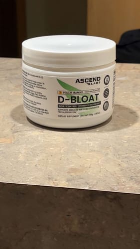 Customer's white tub of D-BLOAT Peach Mango powder sitting on a countertop.