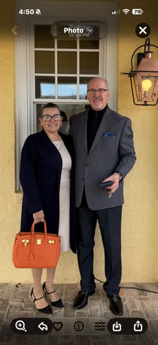 Reviewer holding a structured, bright orange LALUVA Warkin Bag while dressed for an occasion.