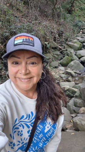 Reviewer smiling outdoors while wearing the cream-colored Unisex Crema Colibri Sweatshirt.