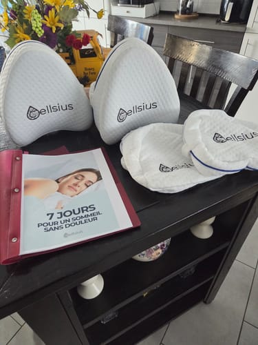 Photo d'un client montrant deux coussins pour genoux Cellsius blancs et autres articles de la marque sur une table.