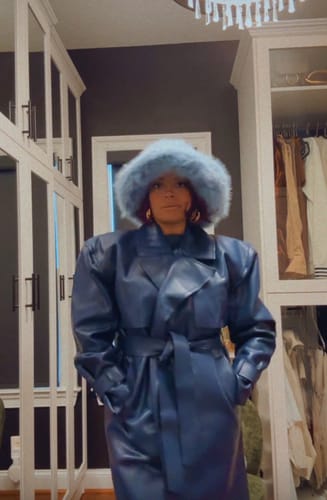 Reviewer wearing the blue Vegan Leather Trench Coat with oversized shoulders, standing in a walk-in closet.