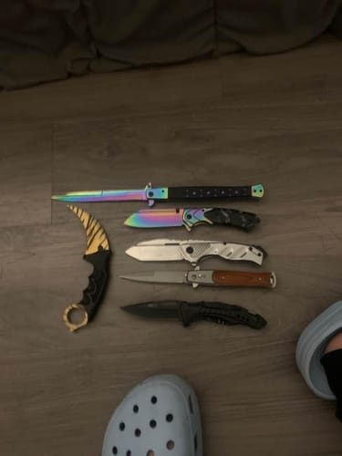 Customer's Mystery Knife Pack showing the 6 assorted knives received, including a karambit and a stiletto, laid out on a floor.