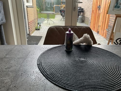 Customer's JNR Falcon Bar 48000 vape standing on a dark tabletop next to a round placemat.