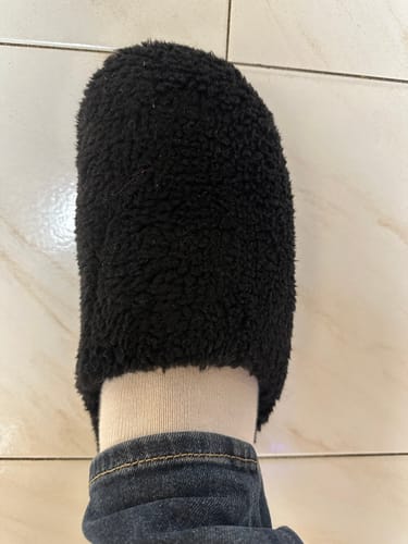 תקריב של נעל הבית Teddy Black השחורה על רגלו של סוקר.