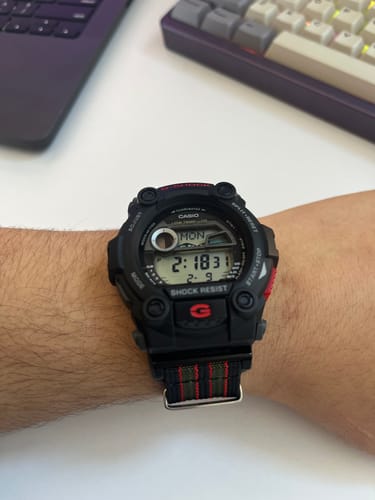 Reviewer's wrist showing the striped Ribbed Mako FN strap attached to a large black digital watch.