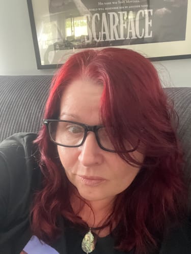 Reviewer shows off her vibrant red hair after using the Instant Dye Shampoo, with roots successfully covered.