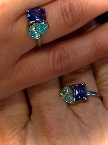 Two people wearing matching Toi Et Moi Birthstone Rings with deep blue and light blue stones.