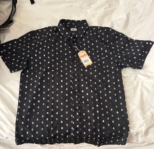 Customer's black 'Lil Troopers (Dark Side)' shirt laid out, showing the colorful all-over stormtrooper helmet pattern.